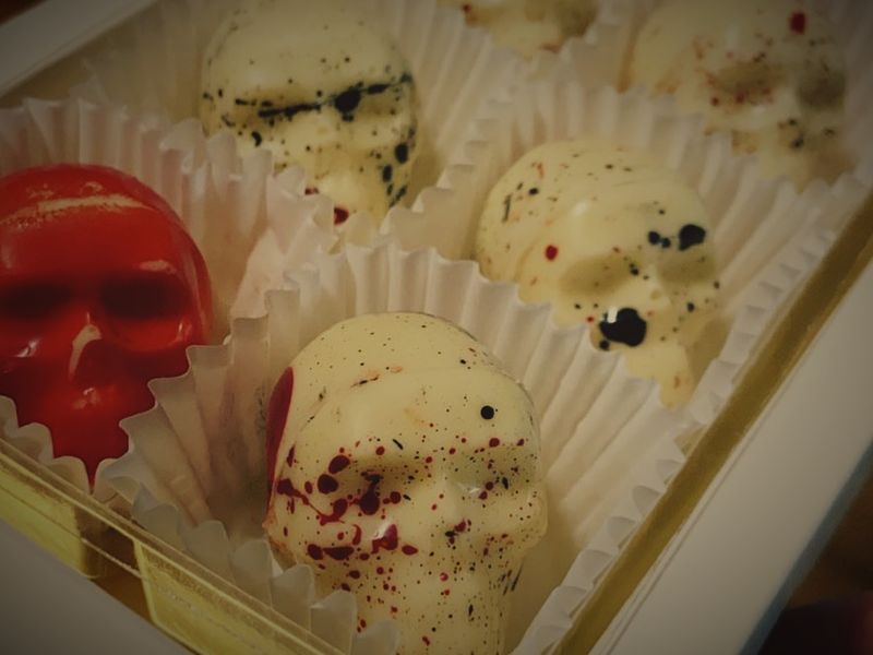 A box of skull-shaped chocolates, speckled white and glossy red